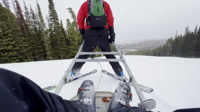 View from behind a patroller pulling a toboggan