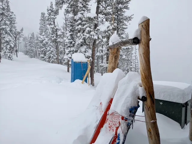Skis leaning against a snow-covered patrol hut