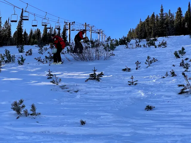 Patrollers practicing on a wide snowy slope