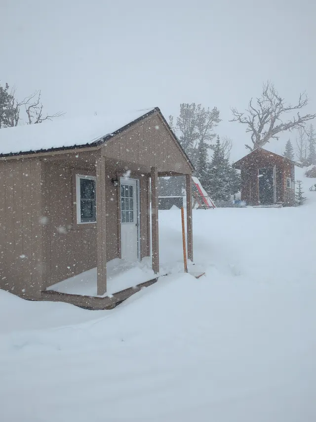 Patrol hut in falling snow
