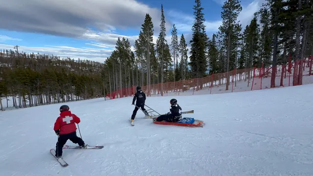 Patrollers and a rescue toboggan on a snowy run