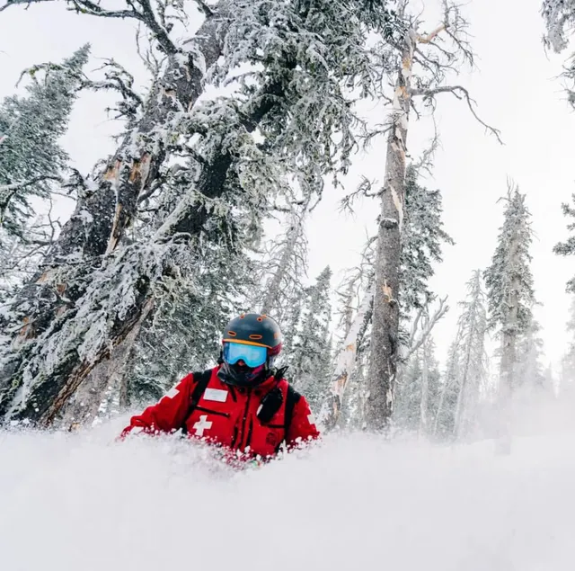 Red-jacketed patroller in fresh snow