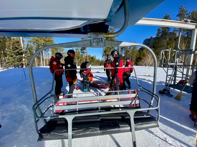 Patrollers and a rescue toboggan on a chairlift