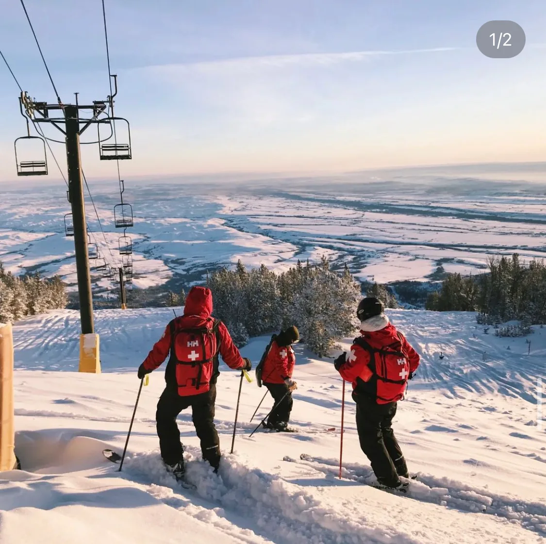 Patrollers near a chairlift above the valley